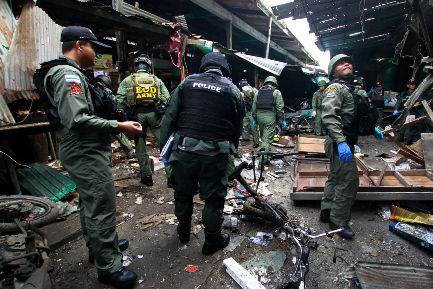 Military personnel and police officers inspect the site of a bomb attack at a market in the southern province of Yala, Thailand, January 22, 2018. REUTERS/Surapan Boonthanom