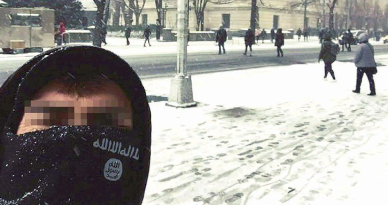 صورة وزعها «داعش» فيها شخص يخفي معالمه وراء علم التنظيم الأسود وفي الخلف صورة «سنترال بارك» (حديقة واشنطن المركزية) (واشنطن بوست)