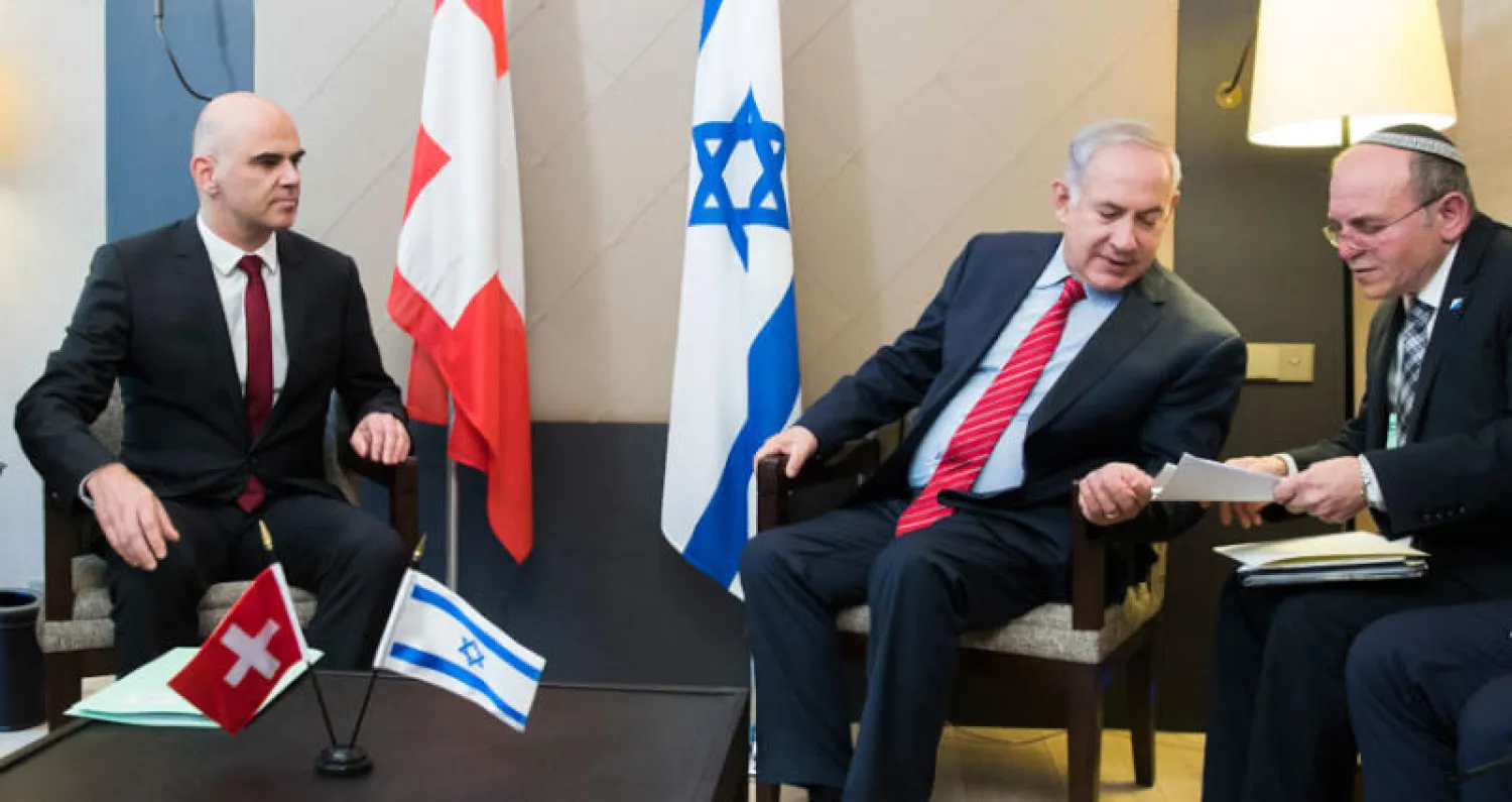 الرئيس السويسري آلان بيرسيت (يسار) وبنيامين نتنياهو (الثاني من اليمين) خلال لقاء في دافوس أمس (أ.ب)