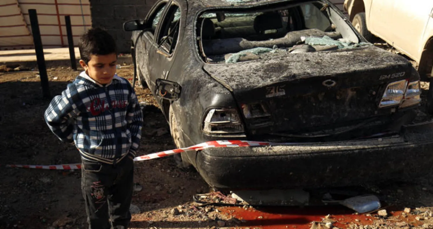 طفل ليبي بجانب إحدى سيارتين فجرتا منذ ايام في بنغازي (إ ب أ)