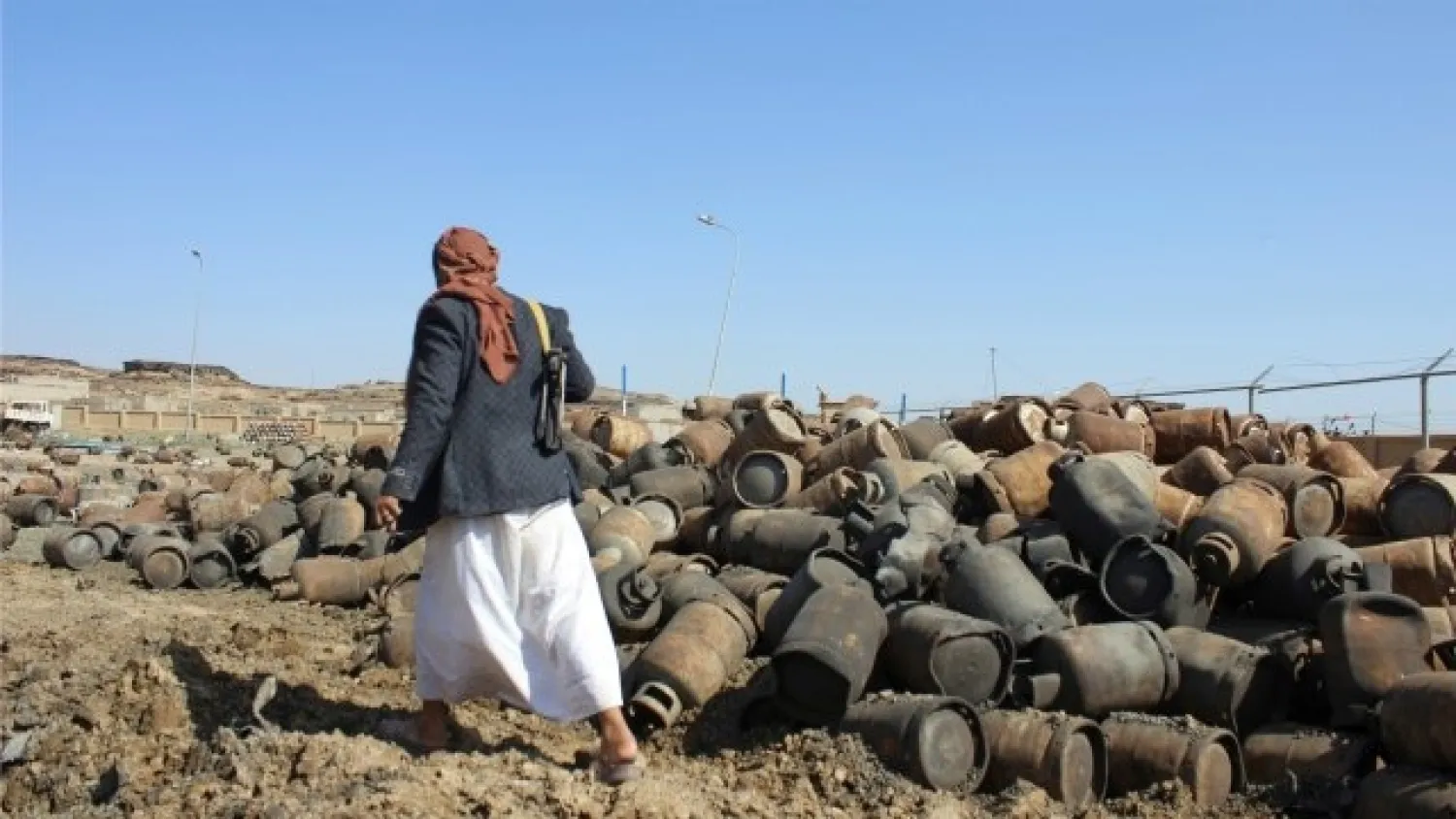 An armed Houthi man walks past cooking gas cylinders in the yard of a gas station in Saada, Yemen August 27, 2016. (File Photo: Reuters)
