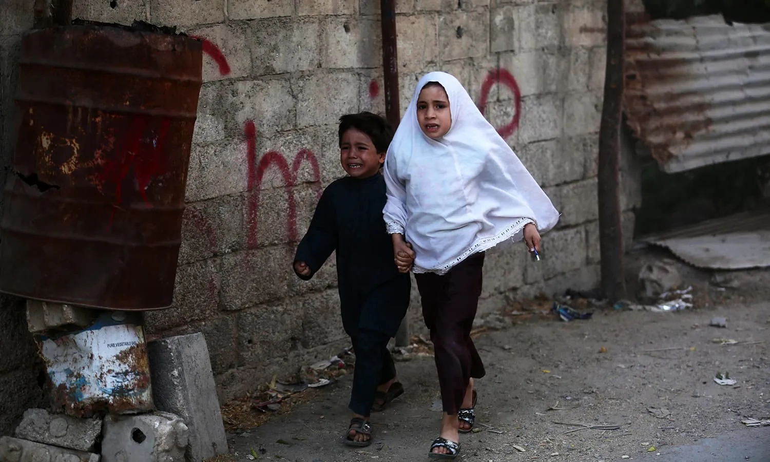 Syrian children run for cover following a reported airstrike on Kafr Batna, in the rebel-held eastern Ghouta area, on the outskirts of the capital Damascus, on September 30, 2016. AFP