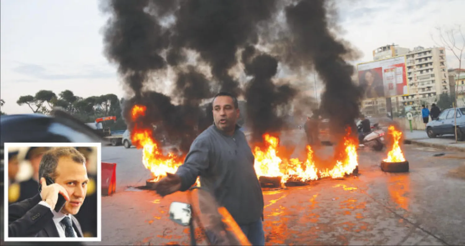 إطارات أشعلها أنصار نبيه بري في أحد شوارع بيروت أمس (أ.ف.ب) ... وفي الإطار جبران باسيل (أ.ب)