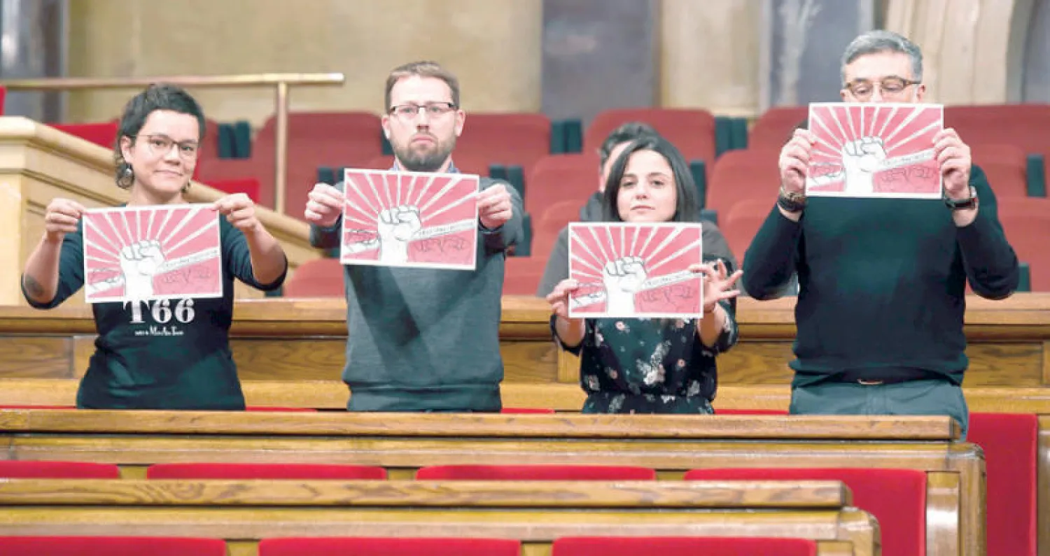 مشرعون يرفعون ملصقات «القوة للشعب» داخل برلمان كاتالونيا (أ.ف.ب)