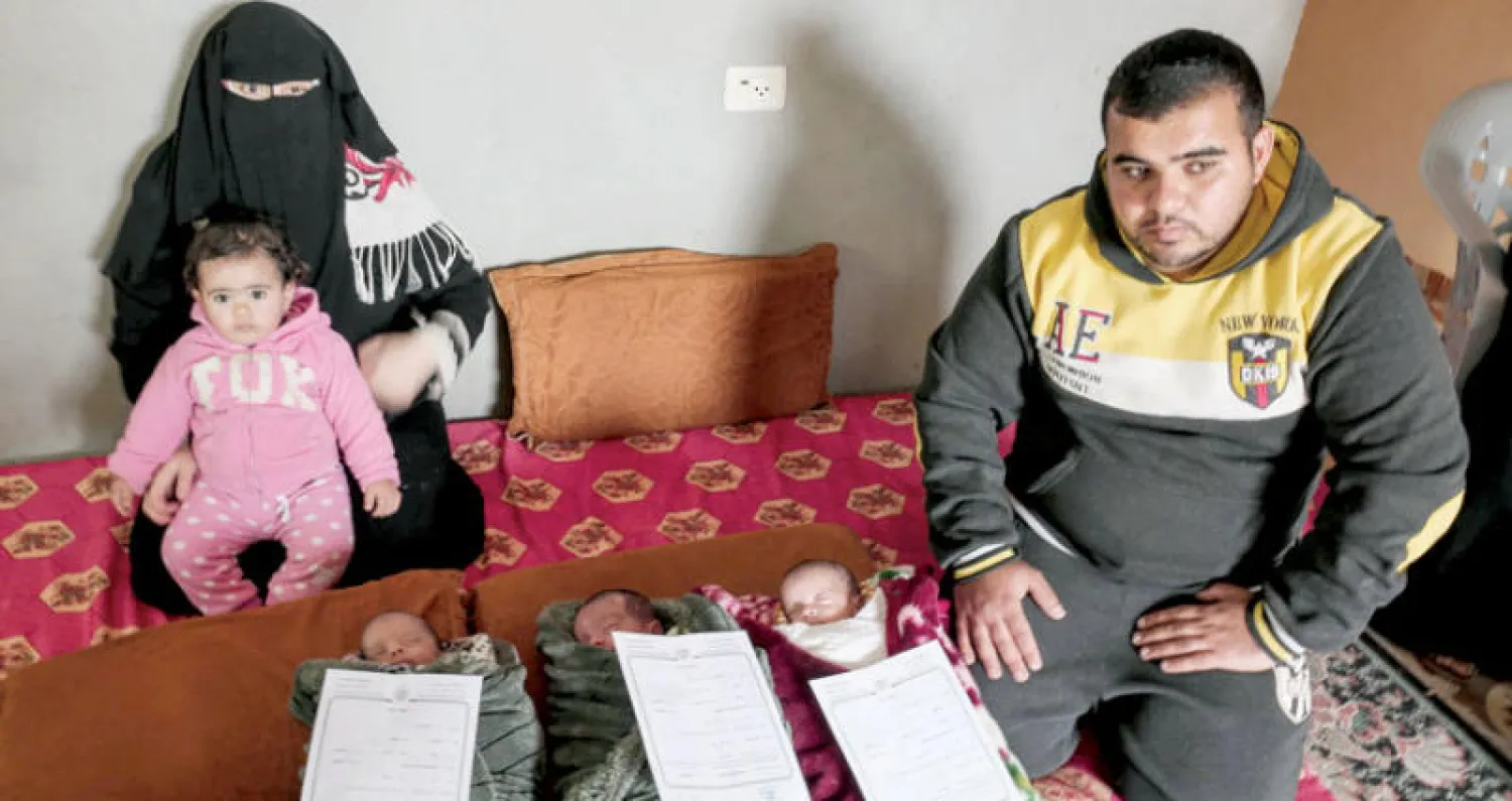 الزوجان إسلام ونضال سيقلي مع ابنتهما دلال والمواليد التوأم الثلاثي في عائلتهما والذين أُطلقت عليهم أسماء «القدس» و«فلسطين» و«العاصمة» في صورة جماعية للأسرة بمنزلها في خان يونس بقطاع غزة أمس (أ.ف.ب)