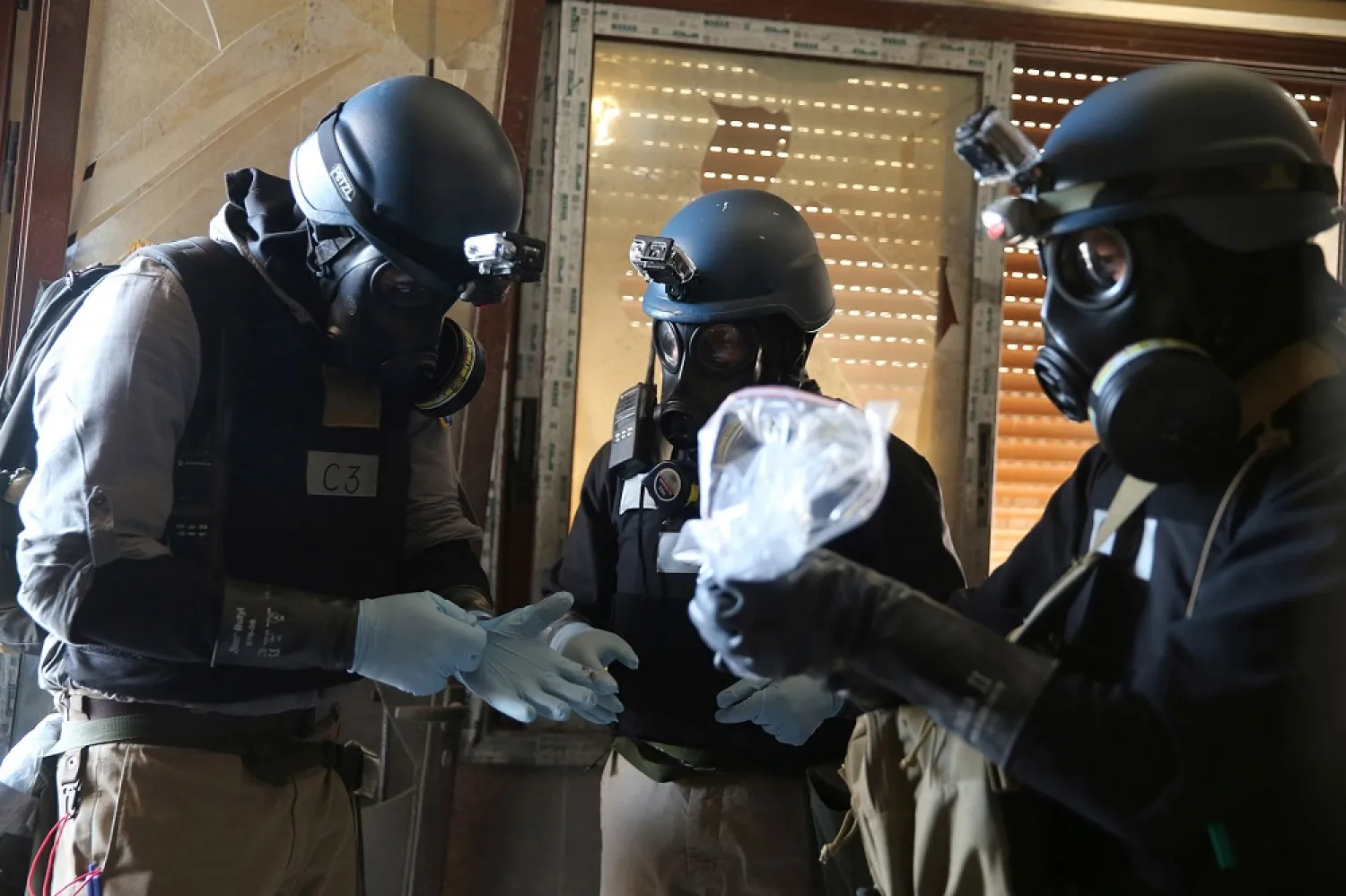 A UN chemical weapons expert holds samples from one of the sites of a chemical weapons attack in the Ain Tarma neighborhood of Damascus in August, 2013. (Reuters)