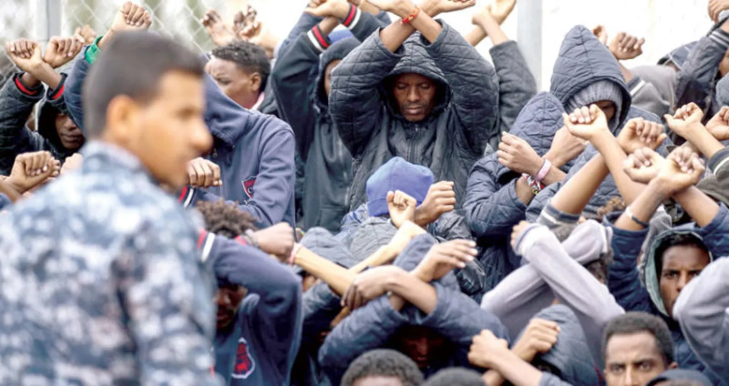 مهاجرون أفارقة في موقف احتجاجي على احتجازهم في معسكر الحمراء بليبيا (أ.ف.ب)