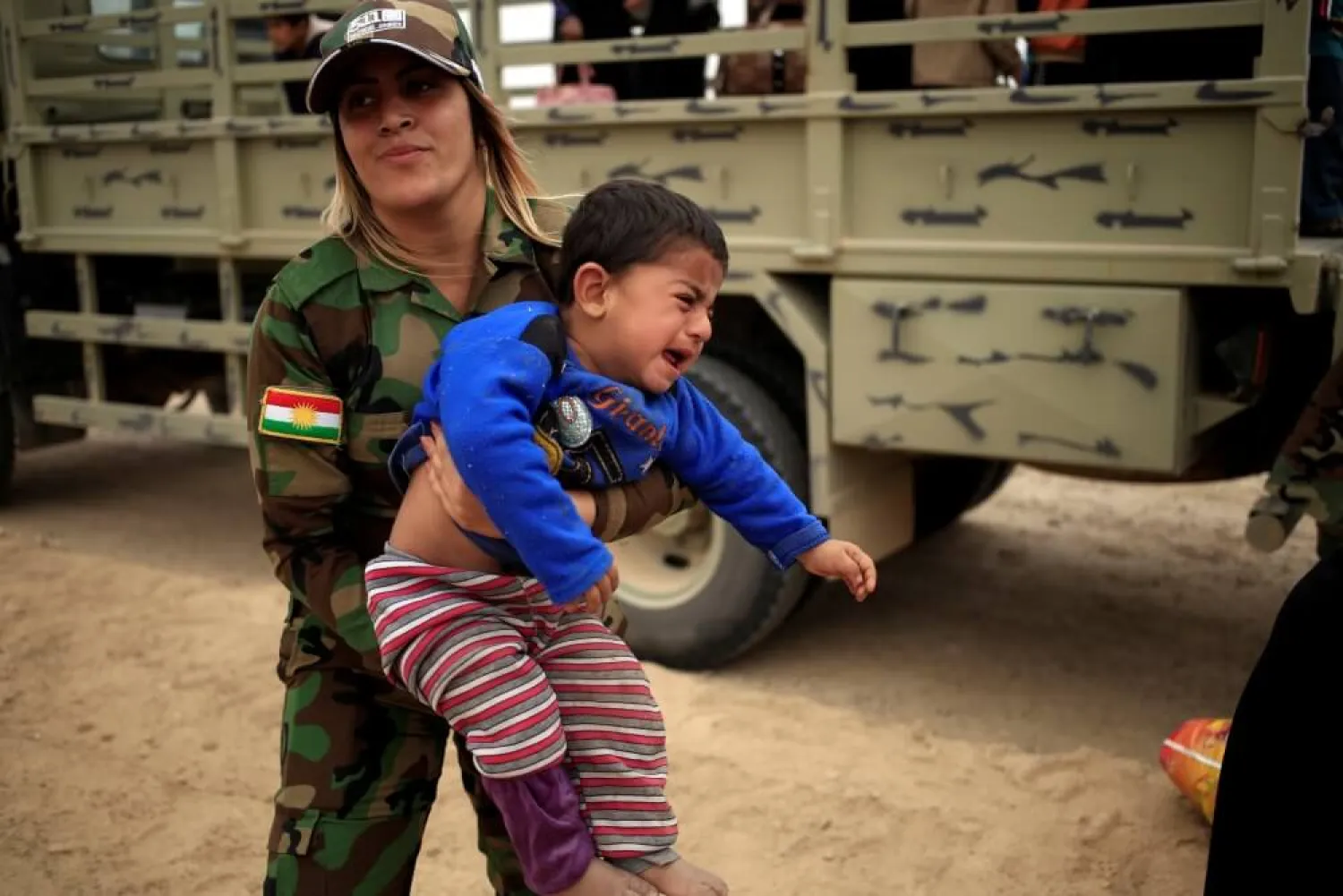 A Kurdish female Peshmerga soldier carries a newly internally displaced boy as he cries upon his arrival at Al Khazar camp near Hassan Sham, east of Mosul, October 25, 2016. (Photo: Reuters/Zohra Bensemra)
