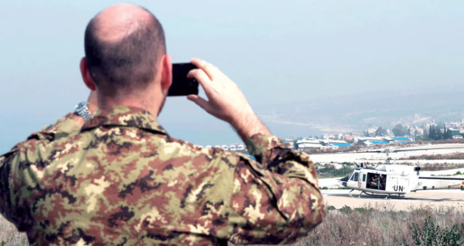 جندي إيطالي في قوات اليونيفيل يلتقط صورة لمروحية في الناقورة تستعد للإقلاع لمراقبة الخط الأزرق الدولي الفاصل بين لبنان وإسرائيل (أ.ب)