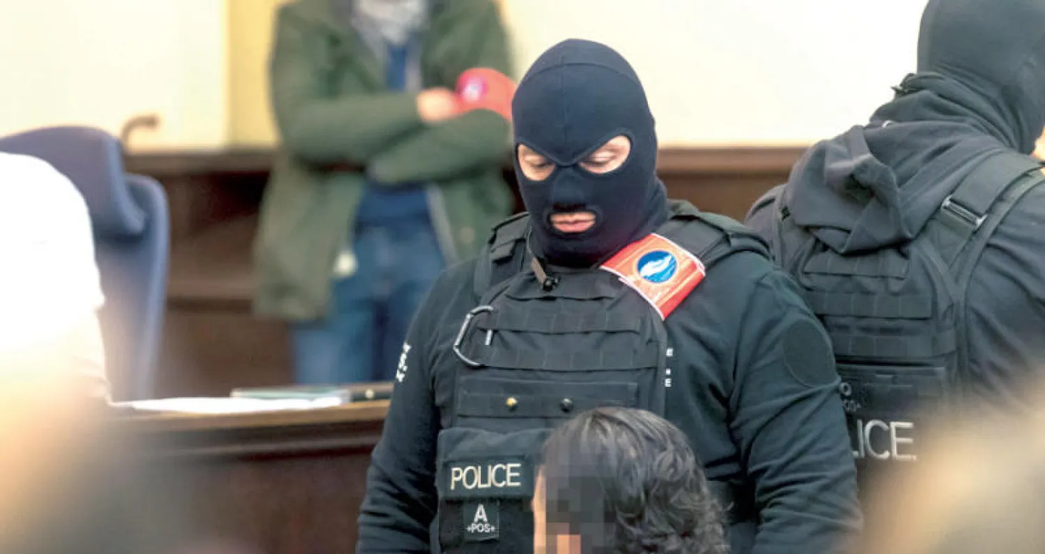 صلاح عبد السلام محاطاً برجال أمن بلجيكيين في بداية جلسات محاكمته في بروكسل يوم الاثنين (إ.ب.أ)