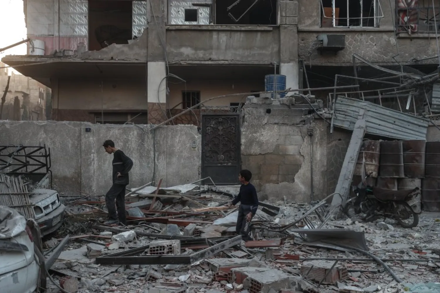 Children look through the rubble near civilian buildings damaged in shelling in Douma, eastern Ghouta, Syria, 07 February 2018. AFP