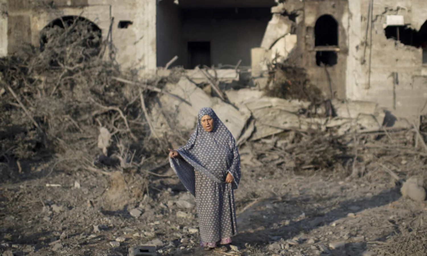 A Palestinian woman gestures as she stands amidst destruction following an Israeli military strike in Gaza City on July 08, 2014. AFP photo