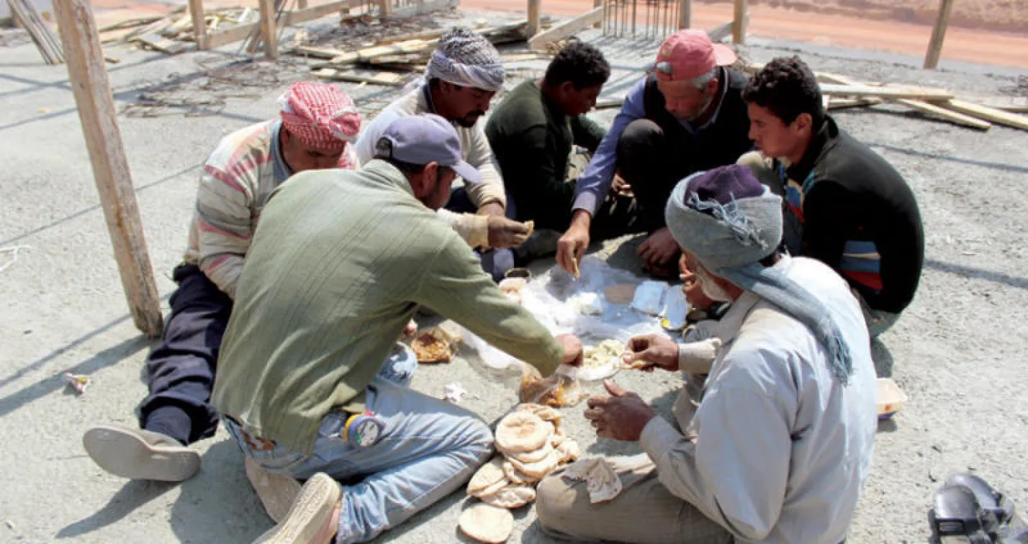 بعض العاملين في بناء تجمعات سكنية جديدة شرق القاهرة يحصلون على قسط من الراحة («الشرق الأوسط»)