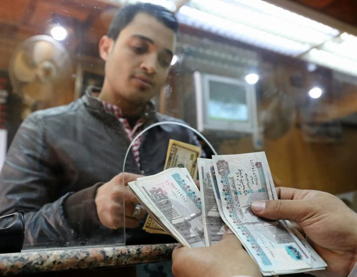 A customer exchanges US dollars to Egyptian pounds in a foreign exchange office in central Cairo, Egypt, March 7, 2017. REUTERS/Mohamed Abd El Ghany 