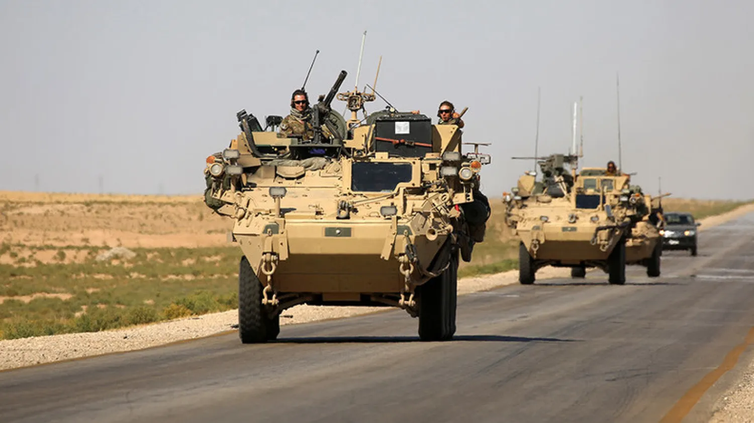 US troops sit atop an armored vehicle on a road near the northern Syrian village of Ain Issa. Delil Souleiman / AFP