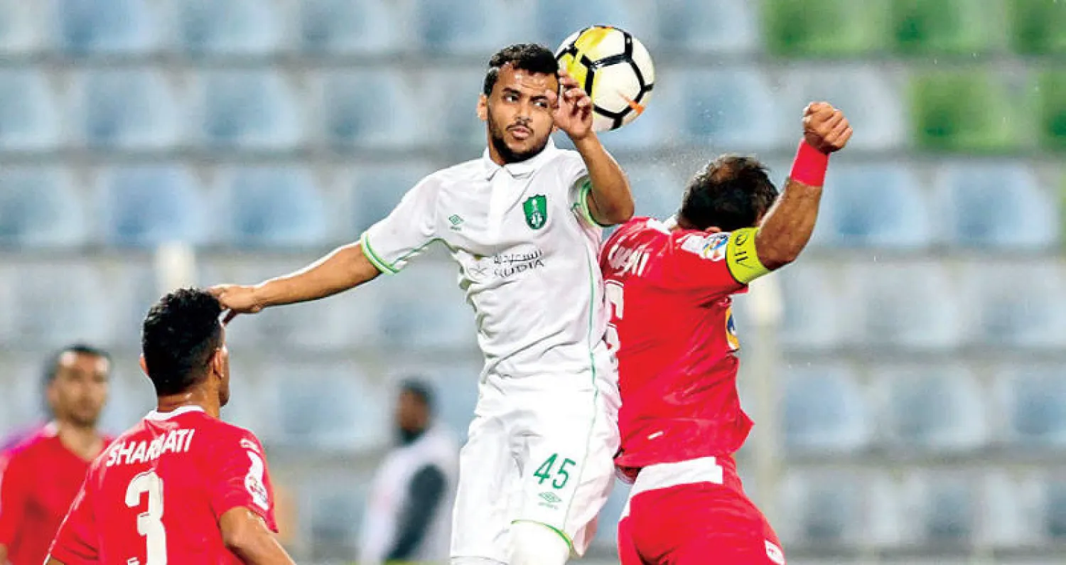 عبد الفتاح عسيري يرتقي للكرة وسط مضايقة اللاعب الإيراني (تصوير: علي خمج)