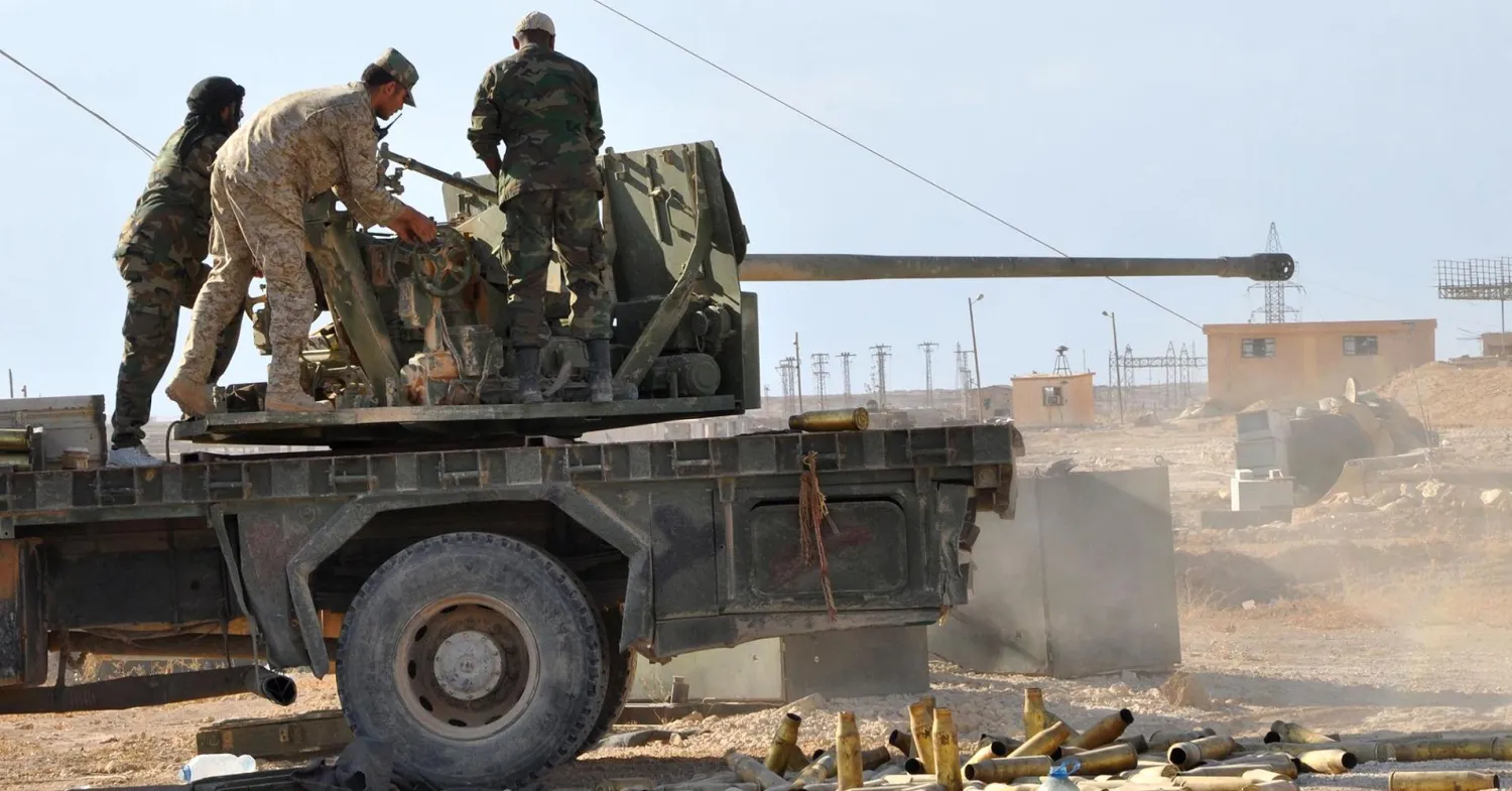 Syrian pro-regime members hold a position as they stand on the back of an armored vehicle in the eastern city of Deir Ezzor, on October 31, 2017, during an operation against ISIS militants. AFP