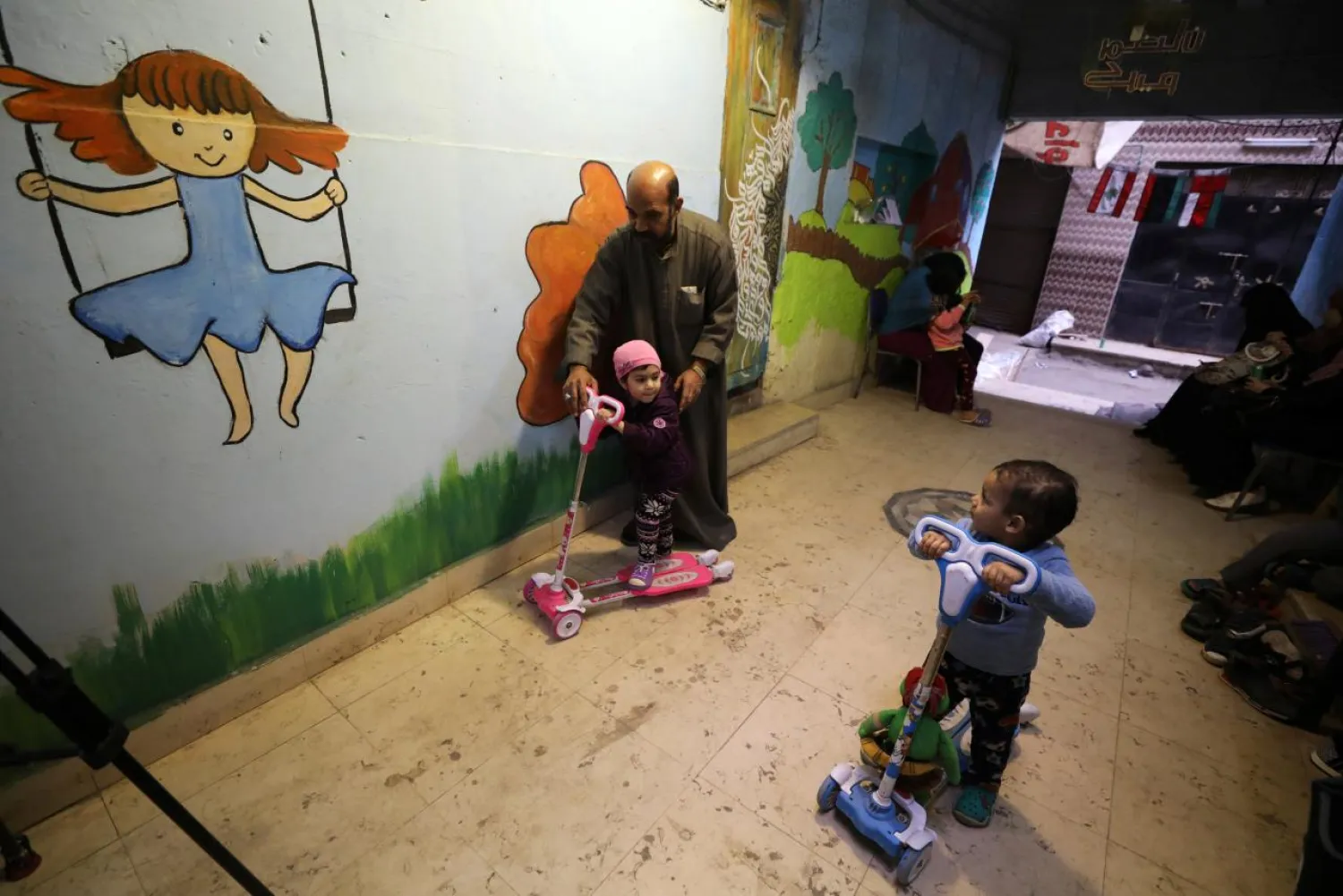 Zaza Ogaz, 50, plays with Yehia, 2, and Retaj, 2, who were diagnosed with cancer, at Ogaz's free housing for patients receiving treatment at a nearby cancer hospital, in Cairo. (Reuters)