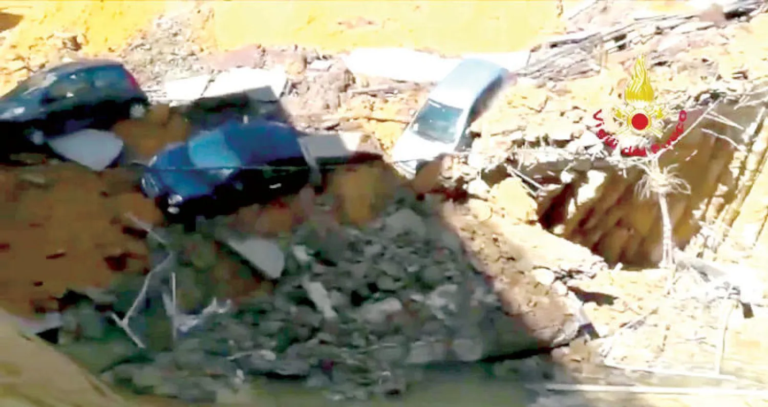 بعض السيارات التي سقطت في الحفرة العميقة  في العاصمة الإيطالية روما (رويترز)