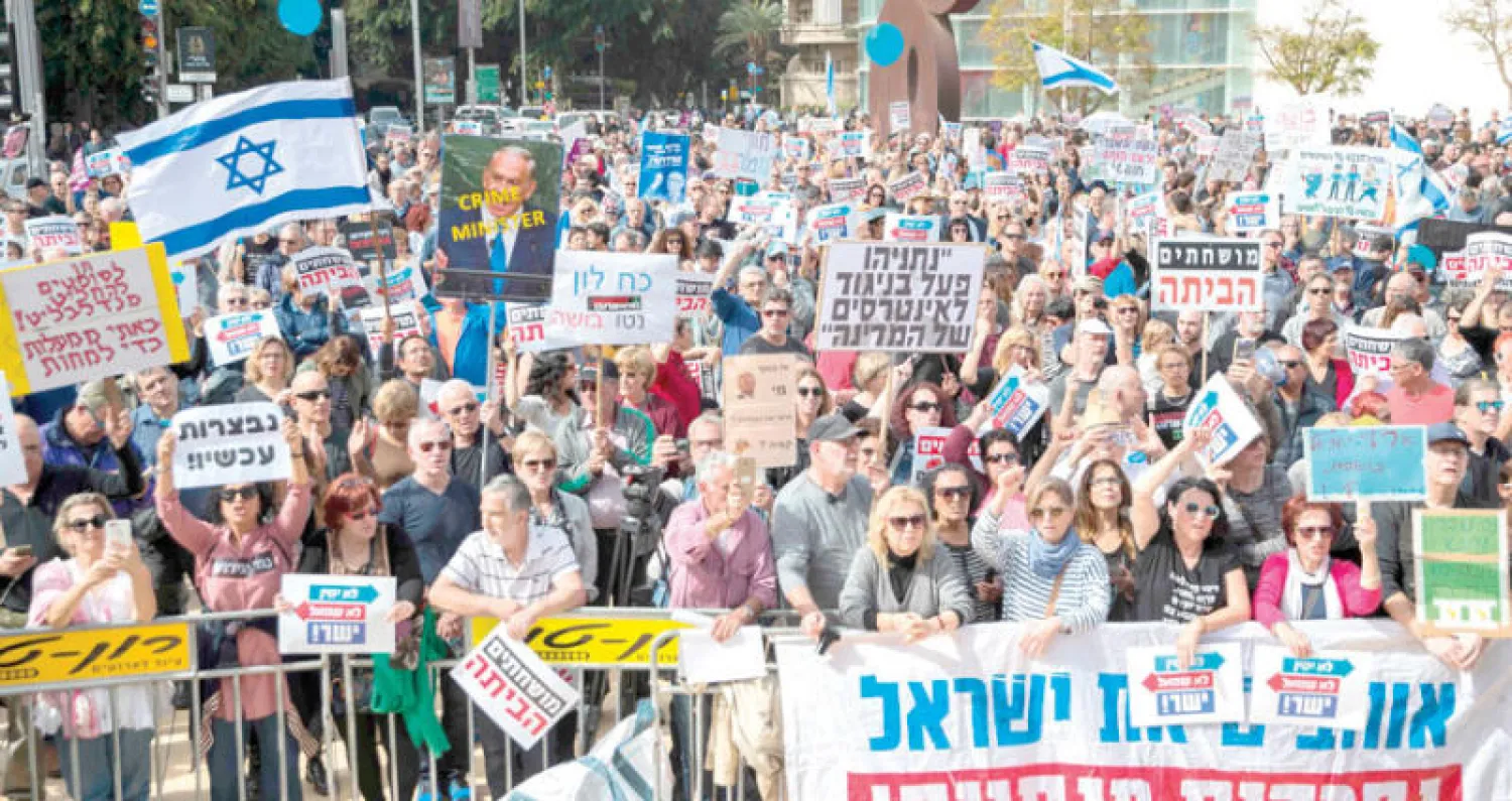 إسرائيليون يتظاهرون مطالبين رئيس الوزراء بنيامين نتنياهو بالاستقالة في تل أبيب أمس (أ.ف.ب)
