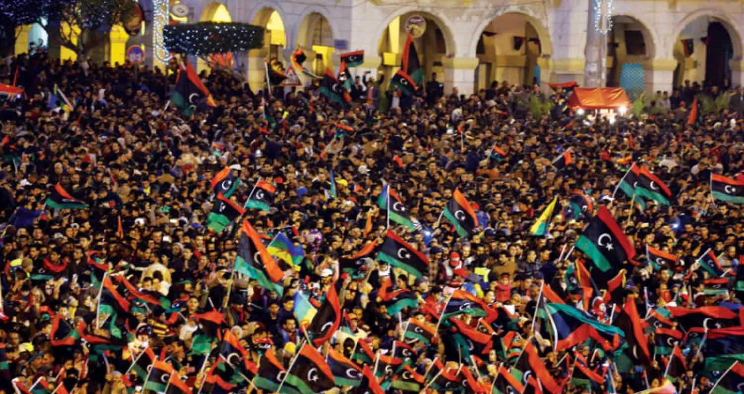 محتفلون بذكرى الثورة الليبية في ساحة الشهداء وسط طرابلس مساء أول من أمس (أ.ف.ب)