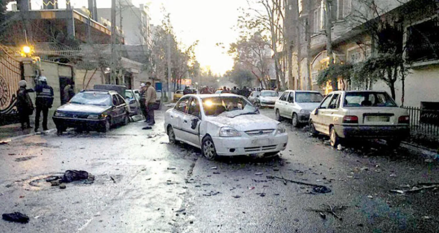 عمال بلدية طهران يرفعون حطام سيارات بعد مواجهات دامية بين قوات الأمن وأنصار طريقة «غناباد» في منطقة باسداران شمال طهران أمس (فارس)