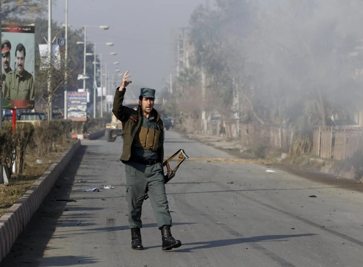 An Afghan policeman reacts as smoke billows during an attack in Jalalabad, Afghanistan. (Reuters)