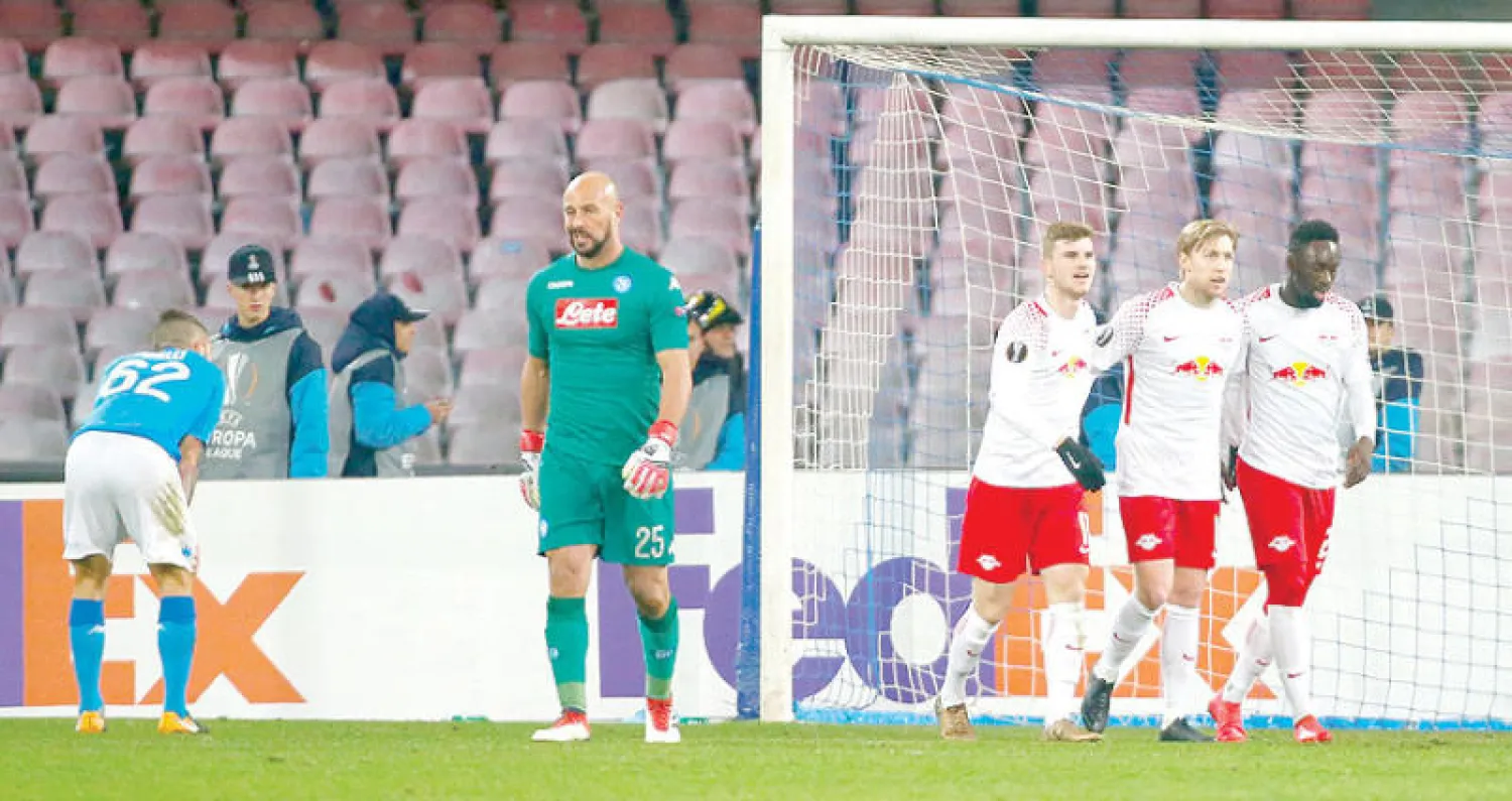 لاعبو لايبزيغ يحتفلون بينما الأسى على ملامح لاعبي نابولي خلال مواجهة الذهاب (رويترز)