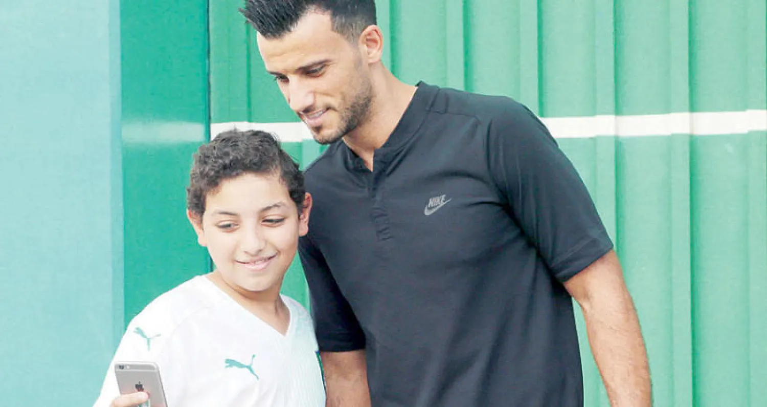 عمر السومة الغائب الأبرز عن فريق الأهلي  يلتقط صورة مع أحد المعجبين («الشرق الأوسط»)