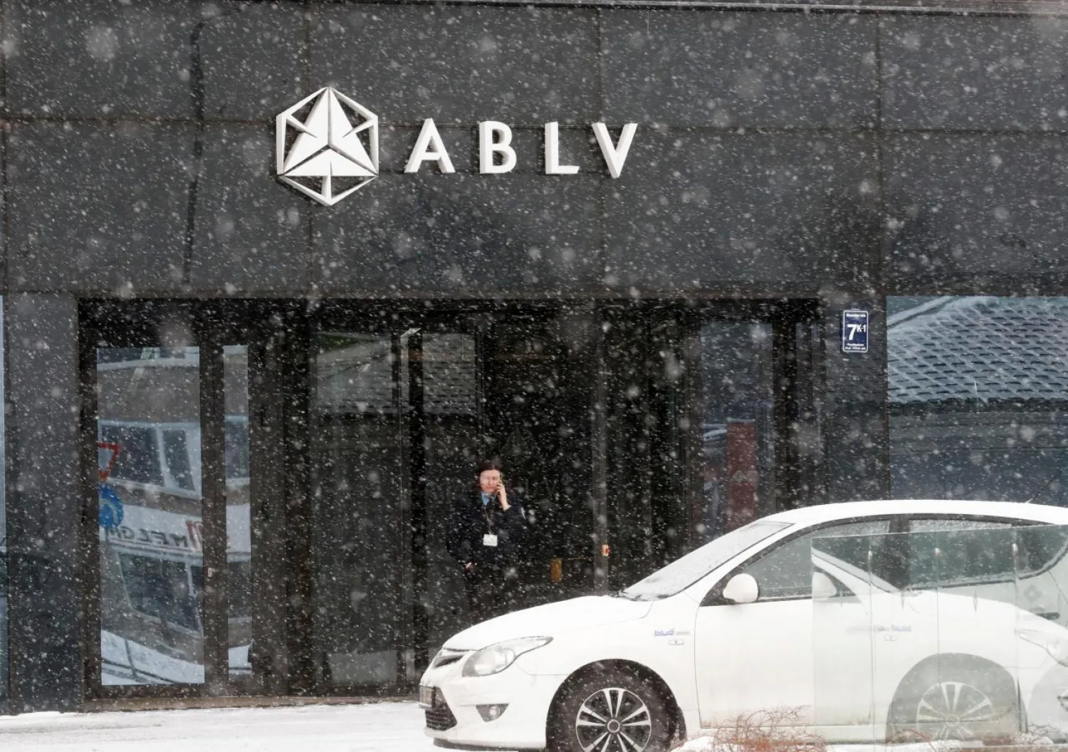 A security guard speaks on her mobile phone at the head office of the ABLV Bank in Riga, Latvia February 18, 2018. REUTERS/Ints Kalnins/File Photo