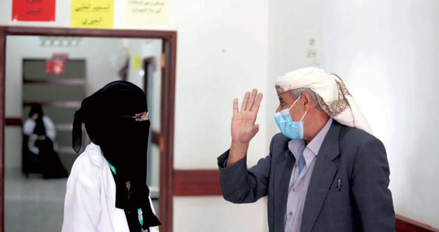 يمني يتحدث إلى ممرضة متطوعة داخل مركز صحي يقدم خدمات طبية مجانية للمحتاجين في صنعاء أمس (رويترز)