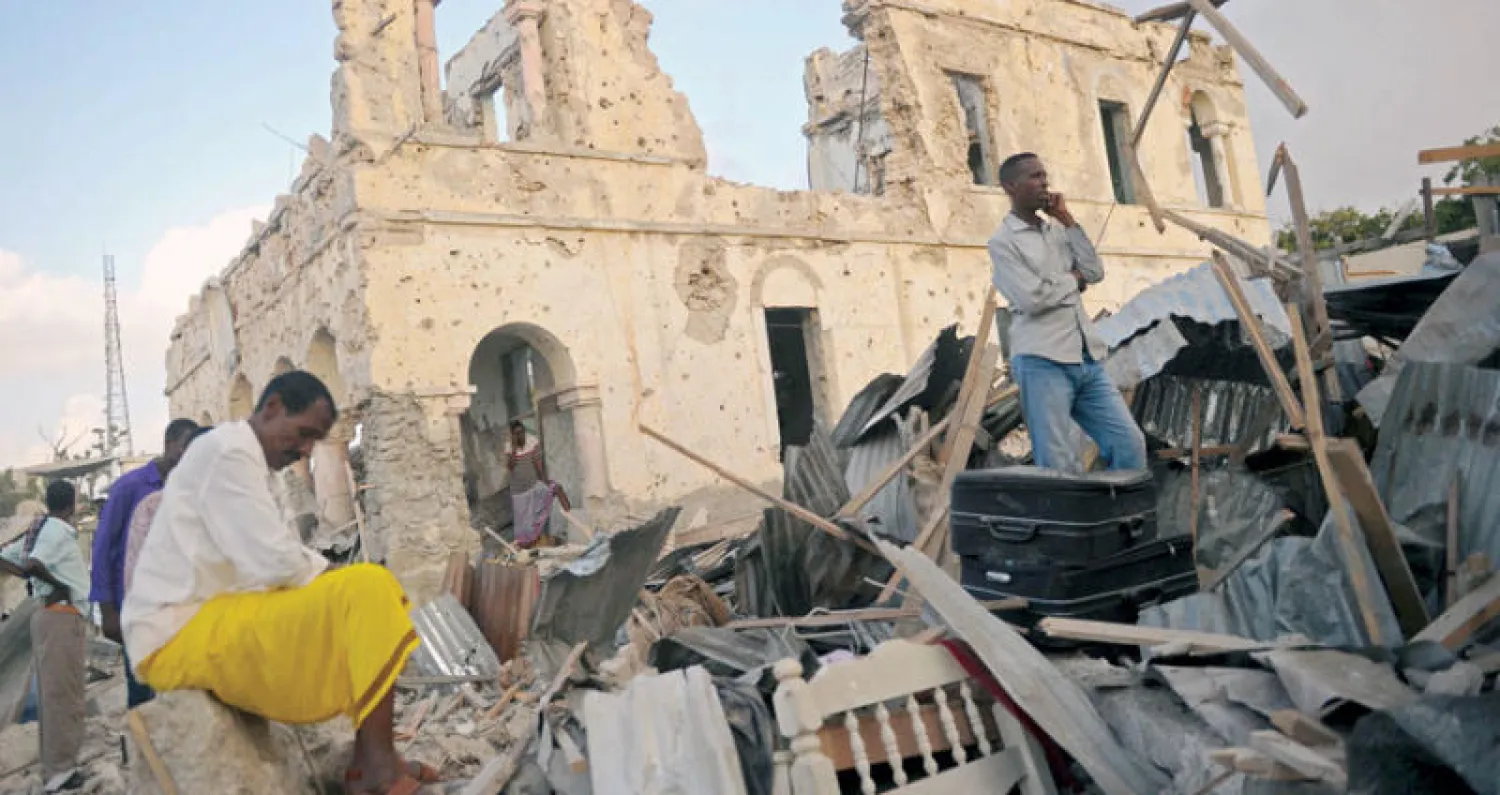 صوماليون يتفقدون آثار تفجير في مقديشو السبت الماضي (أ.ف.ب)