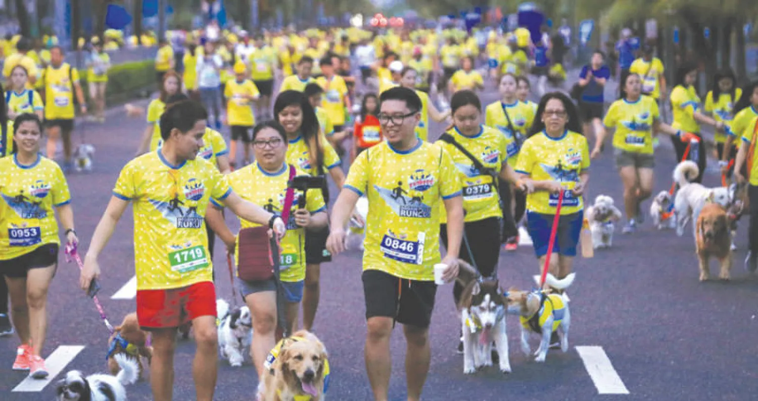 لحظة انطلاق سباق الكلاب بالقرب من مركز {مول آسيا} في مانيلا أمس (رويترز)