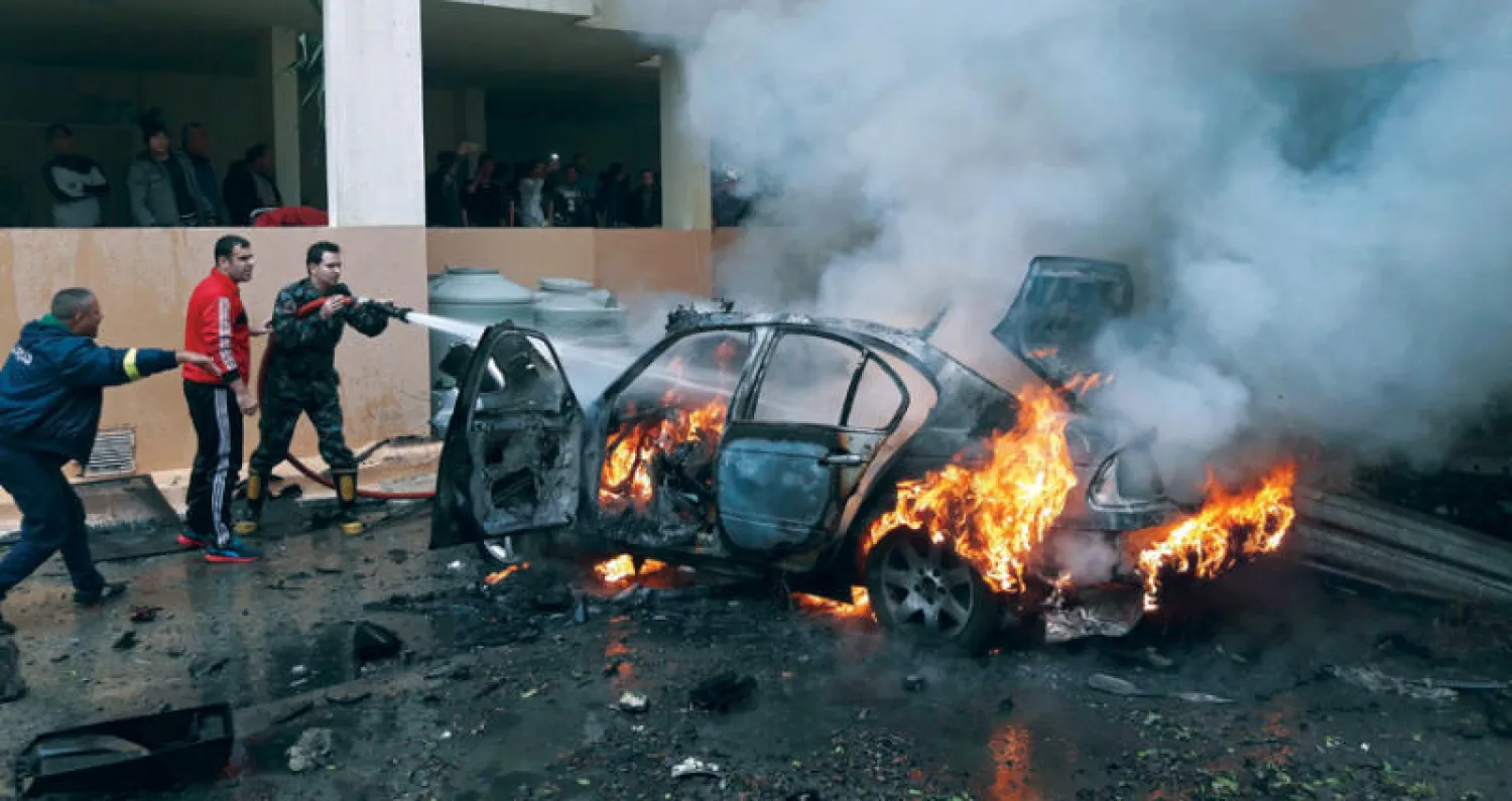 رجل إطفاء لبناني يحاول إخماد نيران انفجار سيارة حمدان بعد محاولة الاغتيال في يناير الماضي (أ.ب)