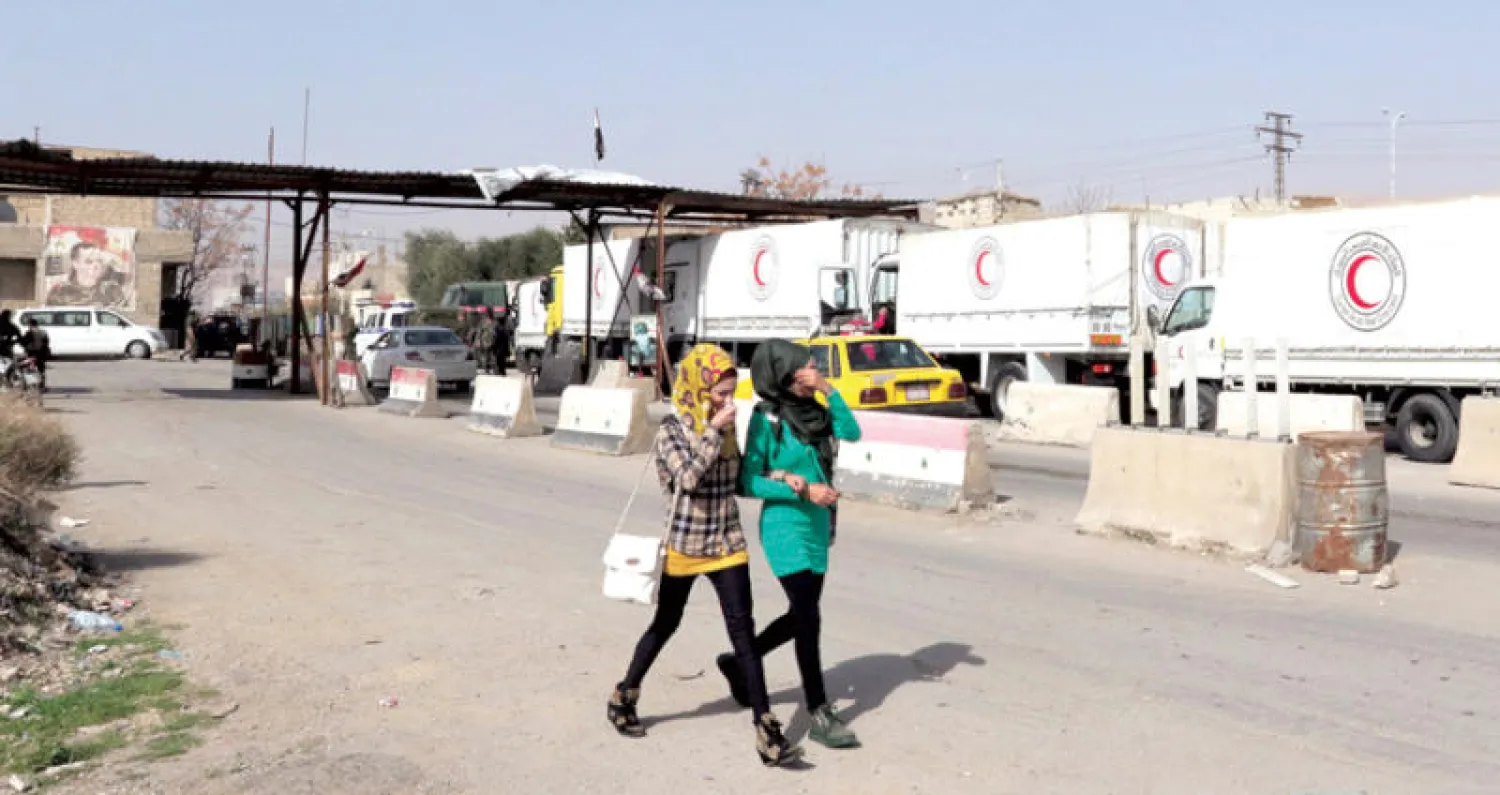 قافلة مساعدات دولية على حاجز لقوات النظام قبل دخول الغوطة أمس (إ.ب.أ)