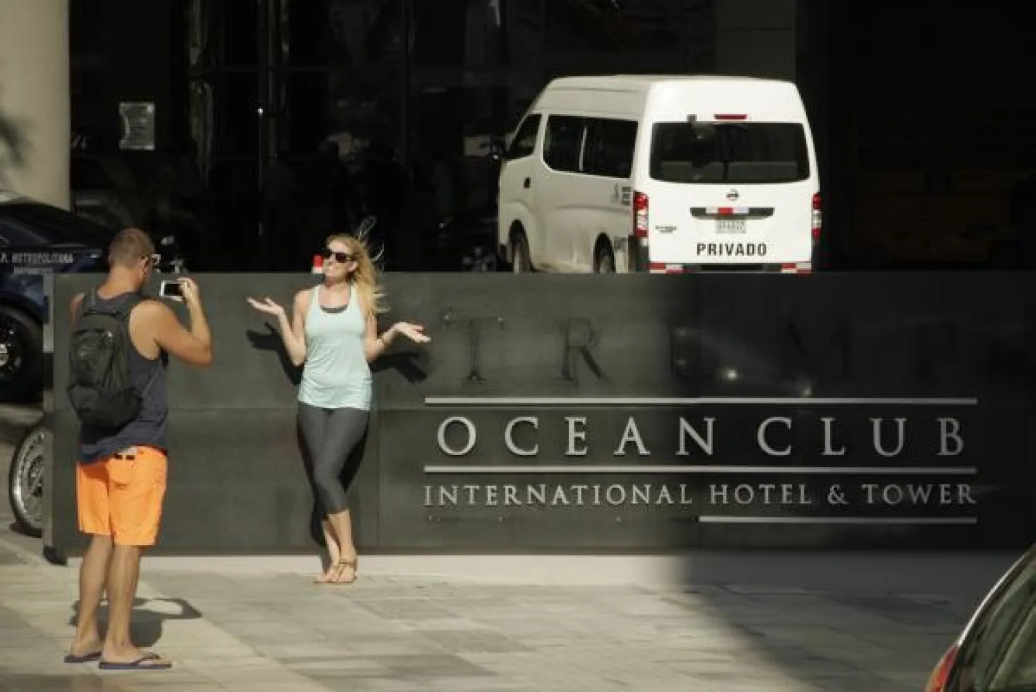 سائحة تلتقط صورة تذكارية عند مدخل الفندق بعد إزالة اسم ترمب. (ا.ب)