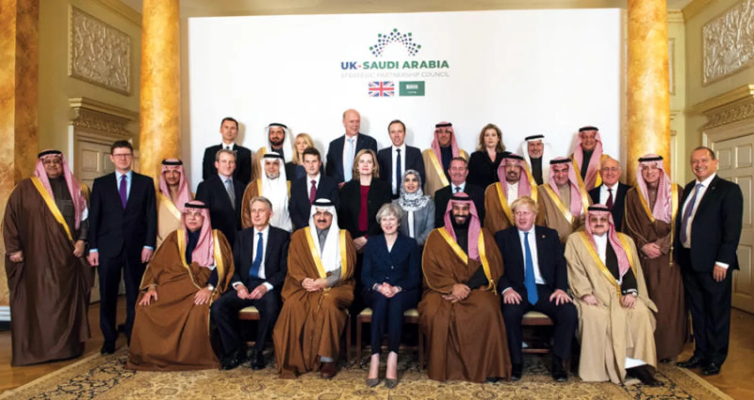 الأمير محمد بن سلمان وتيريزا ماي في صورة تذكارية عقب جلسة المباحثات... ويبدو الأمير محمد بن نواف السفير السعودي في لندن ومسؤولون من الحكومتين السعودية والبريطانية (إ.ب.أ)