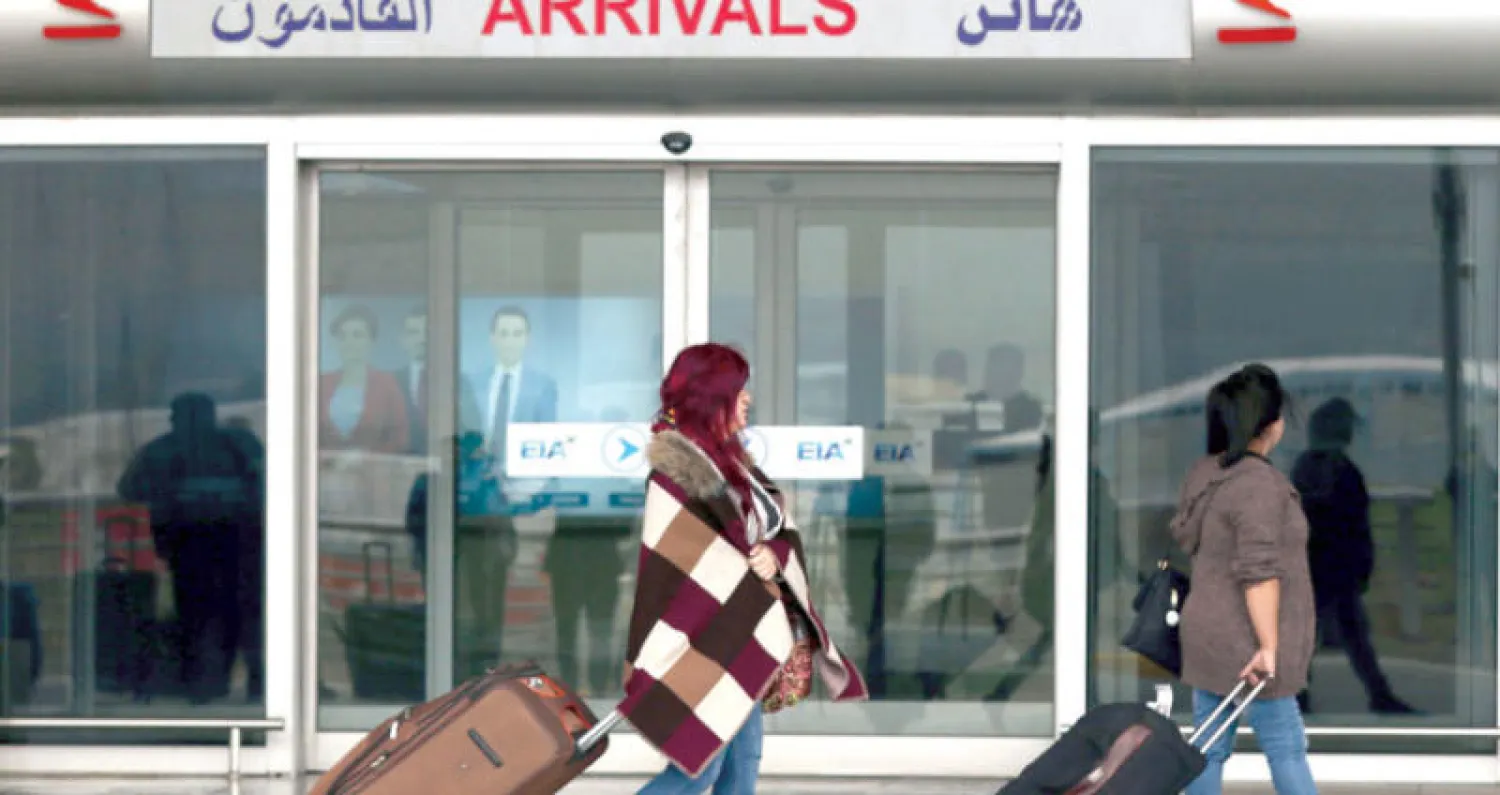 مسافرتان أمام صالة الوصول في مطار أربيل (أ.ف.ب)