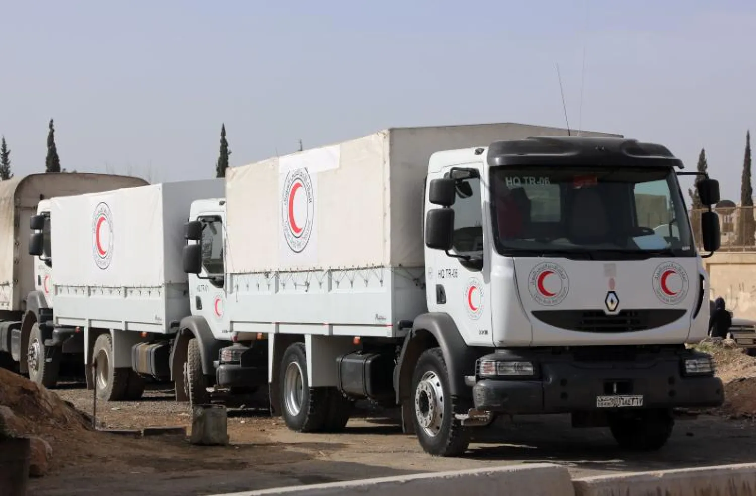 شاحنات ضمن قافلة المساعدات الإنسانية قبل دخولها إلى الغوطة  (أ.ف.ب)