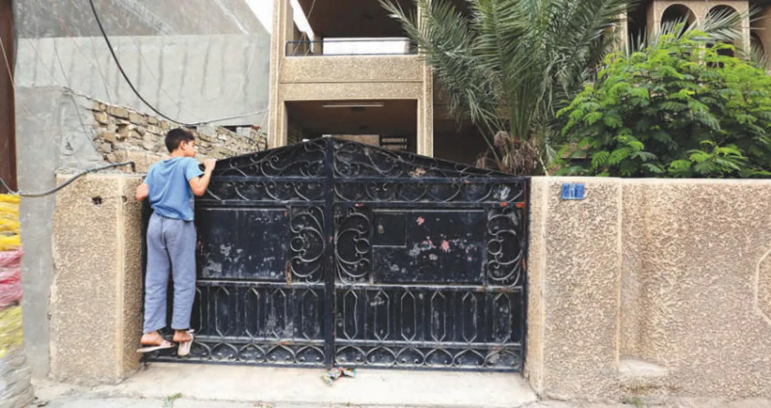 فتى أمام مدخل منزل العائلة المسيحية في بغداد أول من أمس (إ.ب.أ)