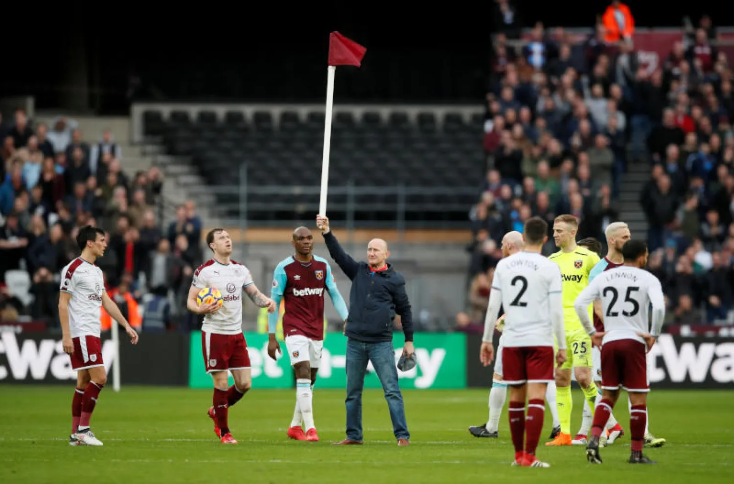 أحد المشجعين يحمل شارة الزاوية الحمراء عقب اقتحام الملعب (رويترز)