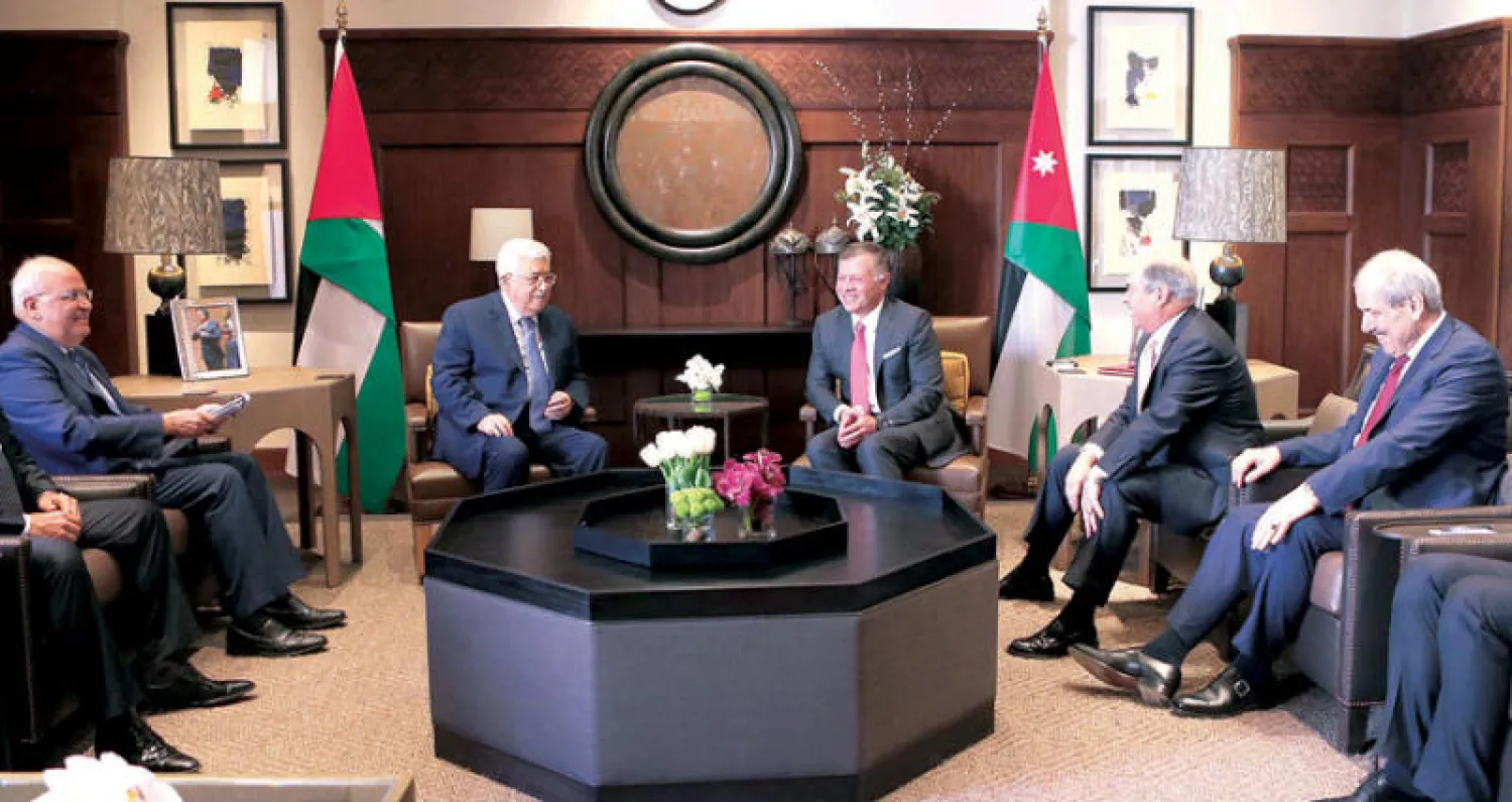العاهل الأردني الملك عبد الله الثاني والرئيس الفلسطيني محمود عباس وأعضاء الوفدين خلال المحادثات في عمان أمس (أ.ف.ب)