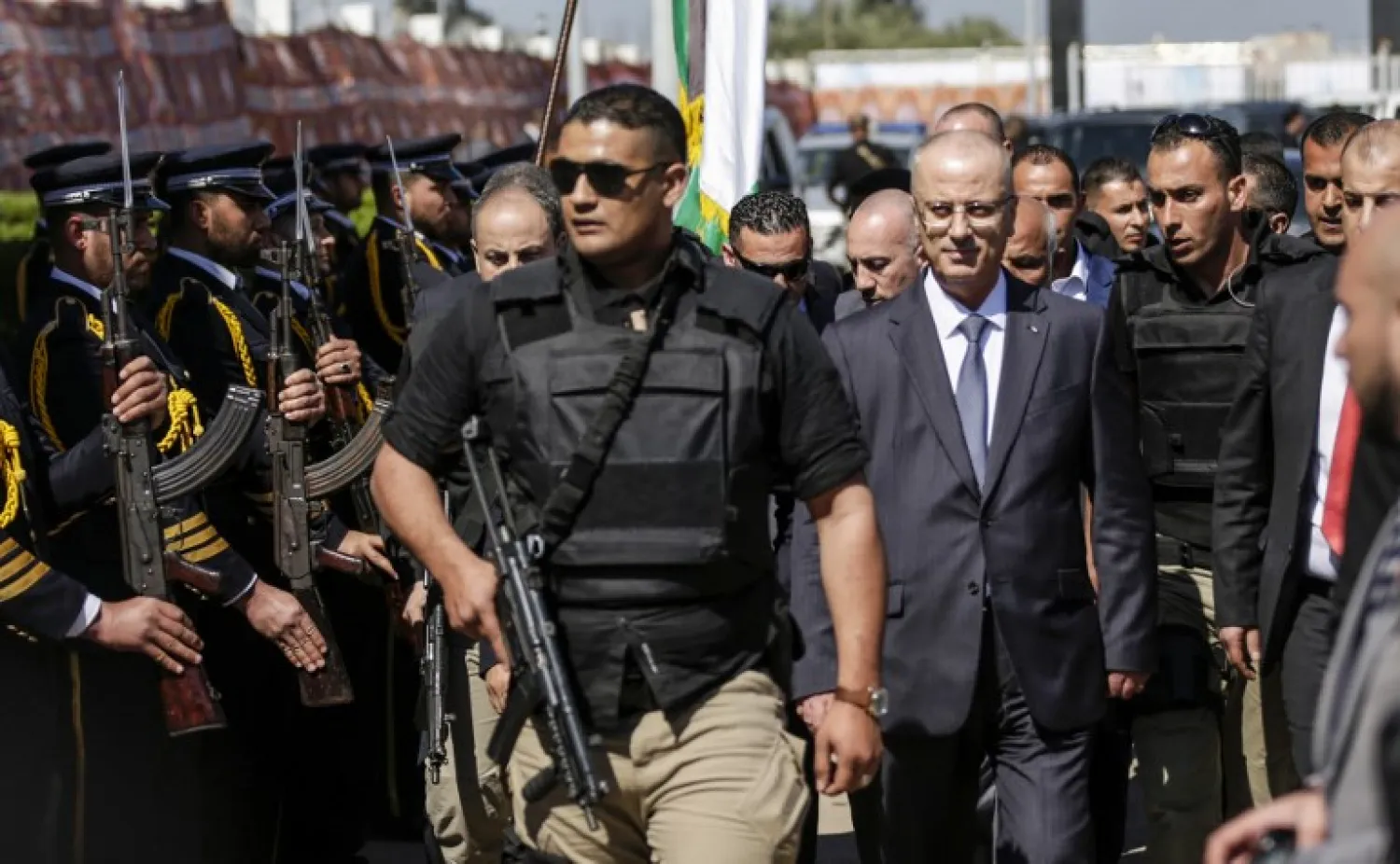 Palestinian Prime Minister Rami Hamdallah (2nd-R), escorted by his bodyguards, is greeted by Hamas police forces (L) upon his arrival in Gaza City on March 13, 2018. (AFP/ Mahmud Hams)