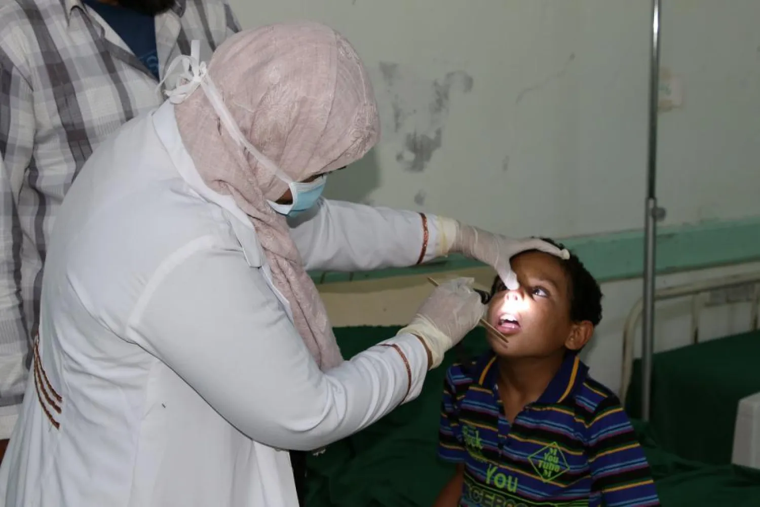 Nahla Arishi, a pediatrician, checks a boy infected with diphtheria at the al-Sadaqa teaching hospital in the southern port city of Aden, Yemen December 18, 2017. REUTERS/Fawaz Salman
