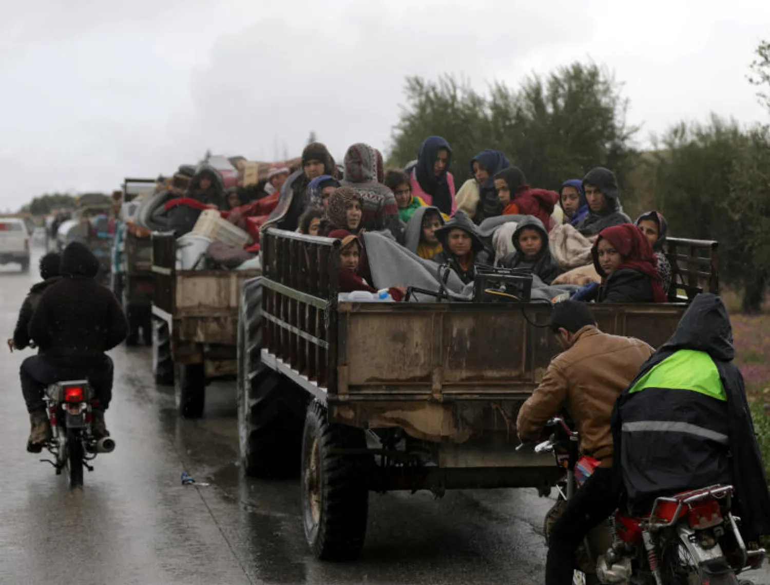 مدنيون يجلسون داخل شاحنات في محاولة للخروج من عفرين السورية (رويترز)