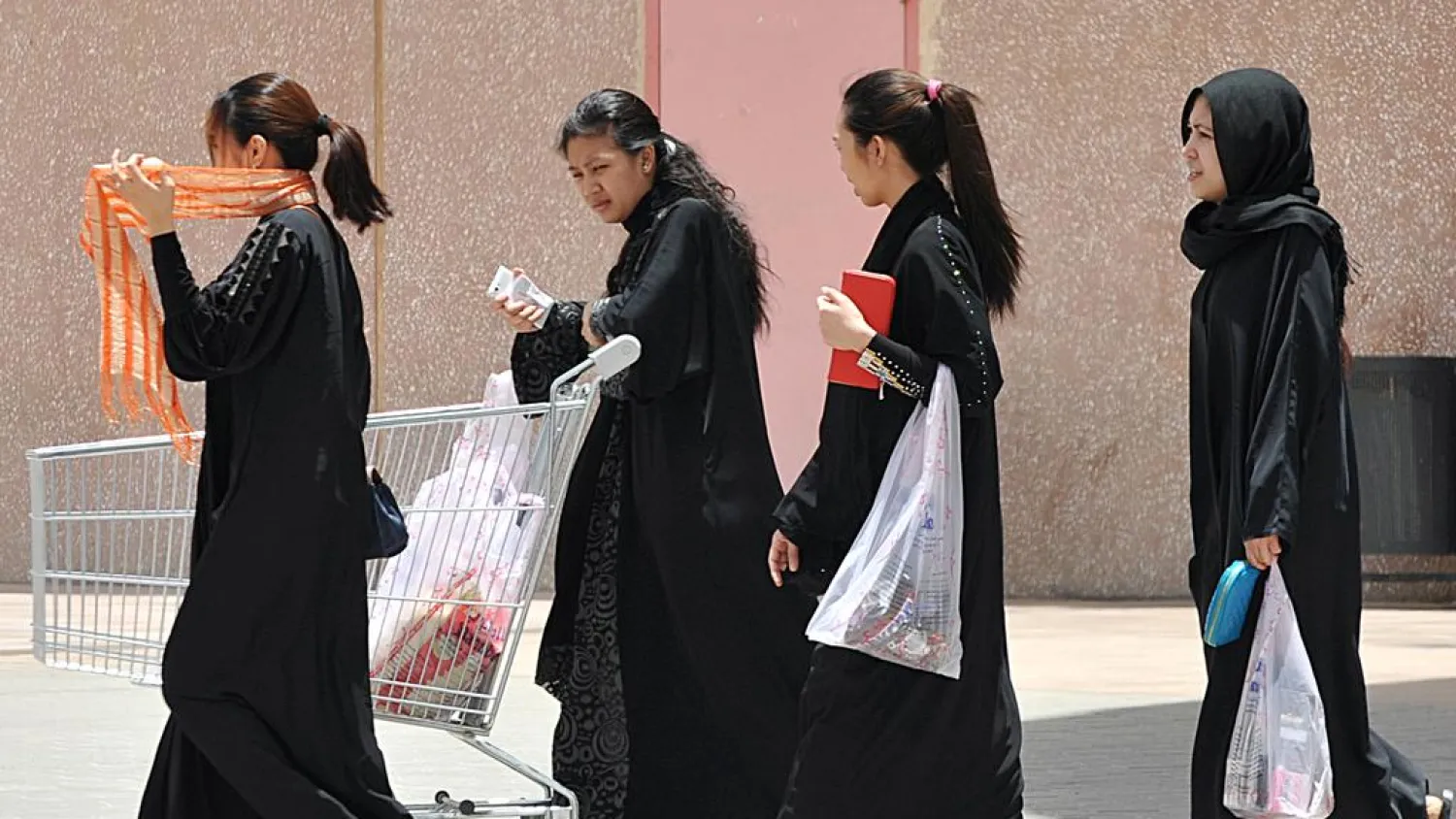 Filipina maids carry shopping bags as they walk out of a mall in Riyadh on June 12, 2013. Fayez Nureldine / AFP Photo