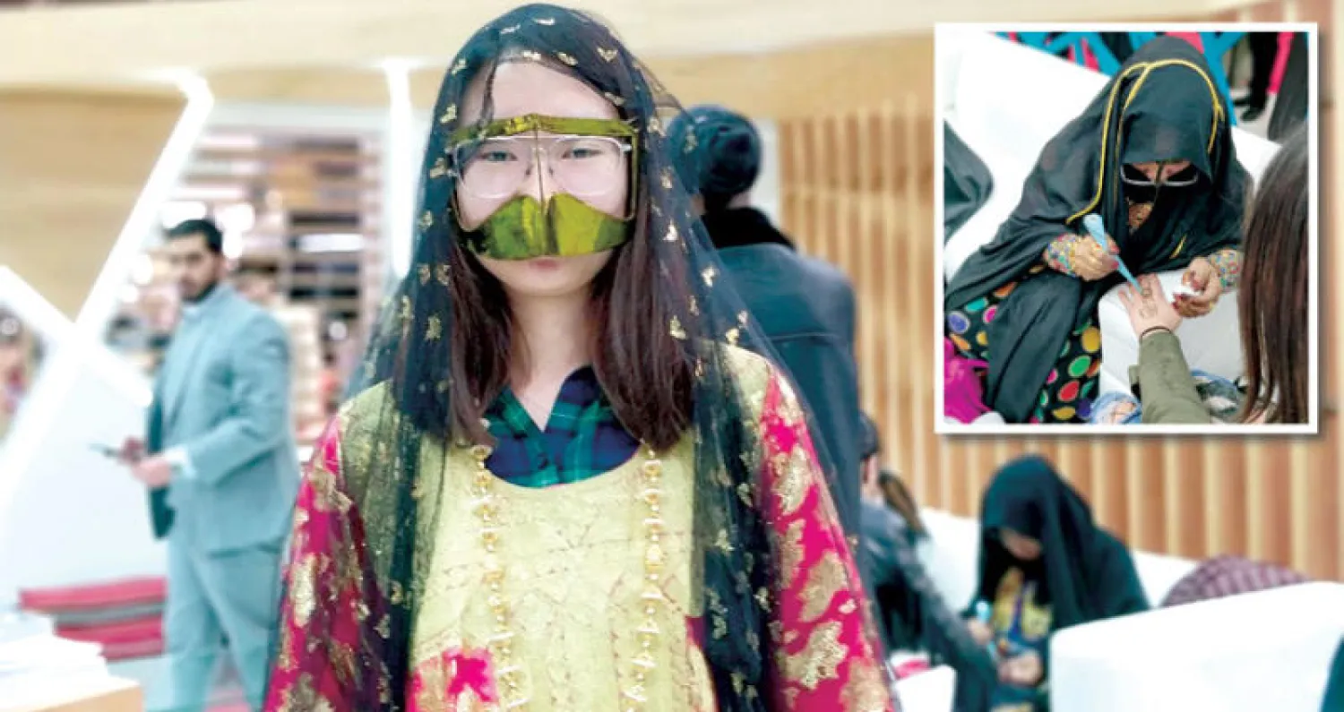 فتاة تلبس البرقع... وفي الإطار إماراتية ترسم بالحناء على يد فتاة