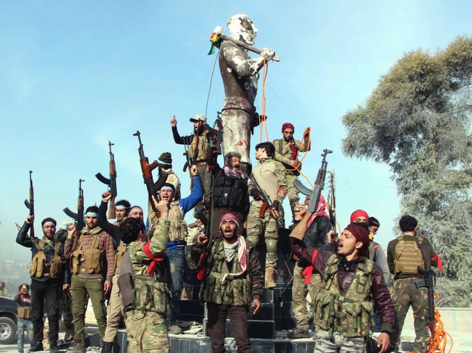 Turkey-backed Free Syrian Army soldiers celebrate around a statue of Kawa, a mythology figure in Kurdish culture as they prepare to destroy it in city center of Afrin, northwestern Syria, early Sunday. Hasan Kirmizitas/AP