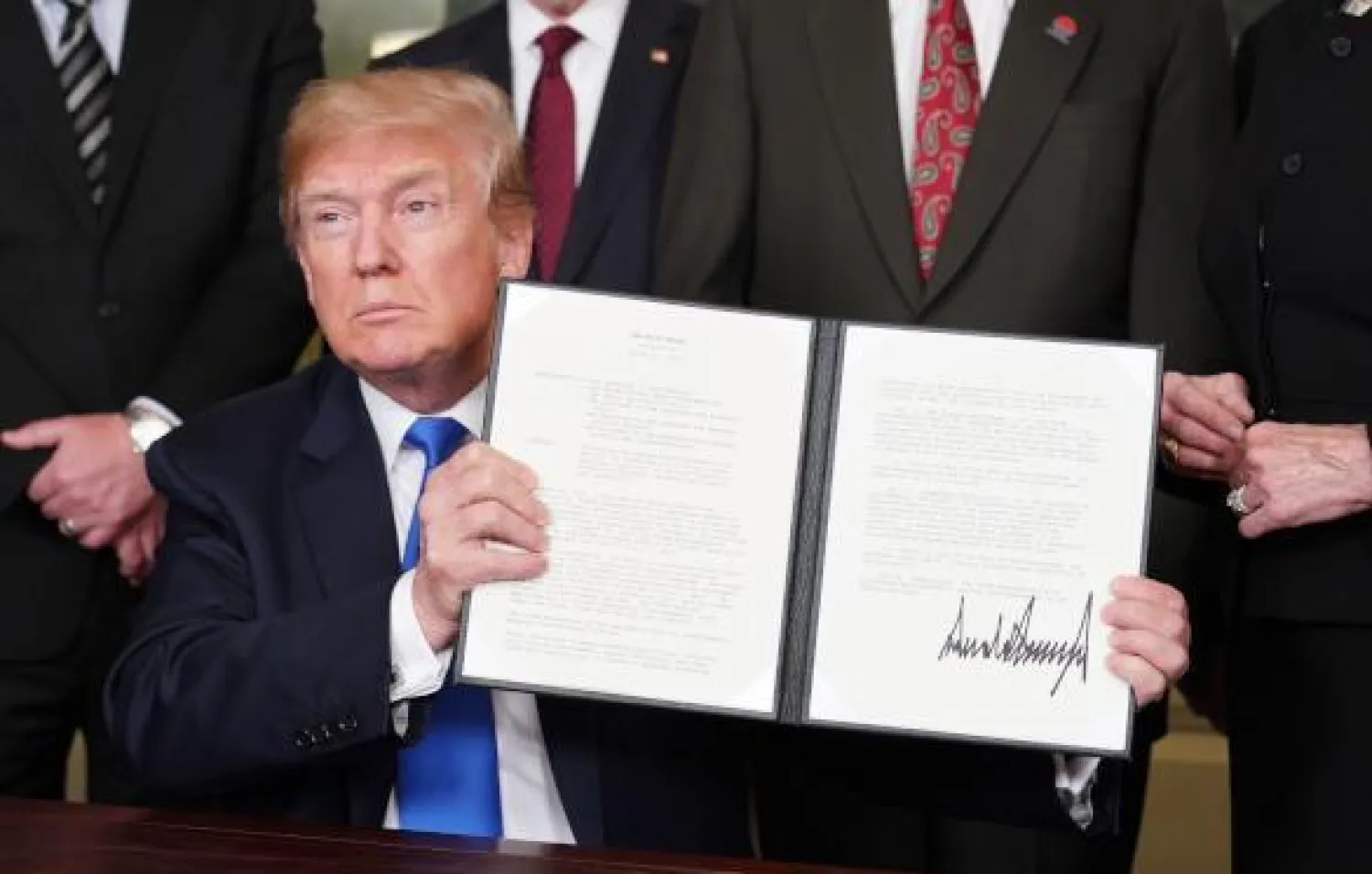 الرئيس الأميركي دونالد ترمب يوقع عقوبات تجارية على الصين في قاعة الاستقبال الدبلوماسية بالبيت الأبيض في واشنطن (أ.ف.ب)