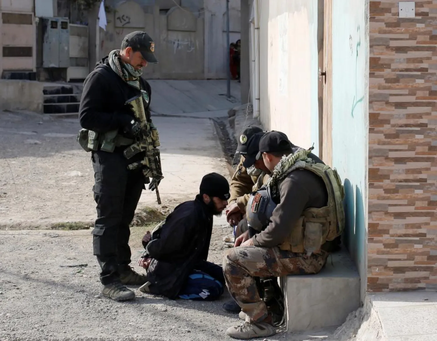 Members of an Iraqi Special forces intelligence team talk to a suspected ISIS member in Mosul, Iraq. (Reuters file photo)